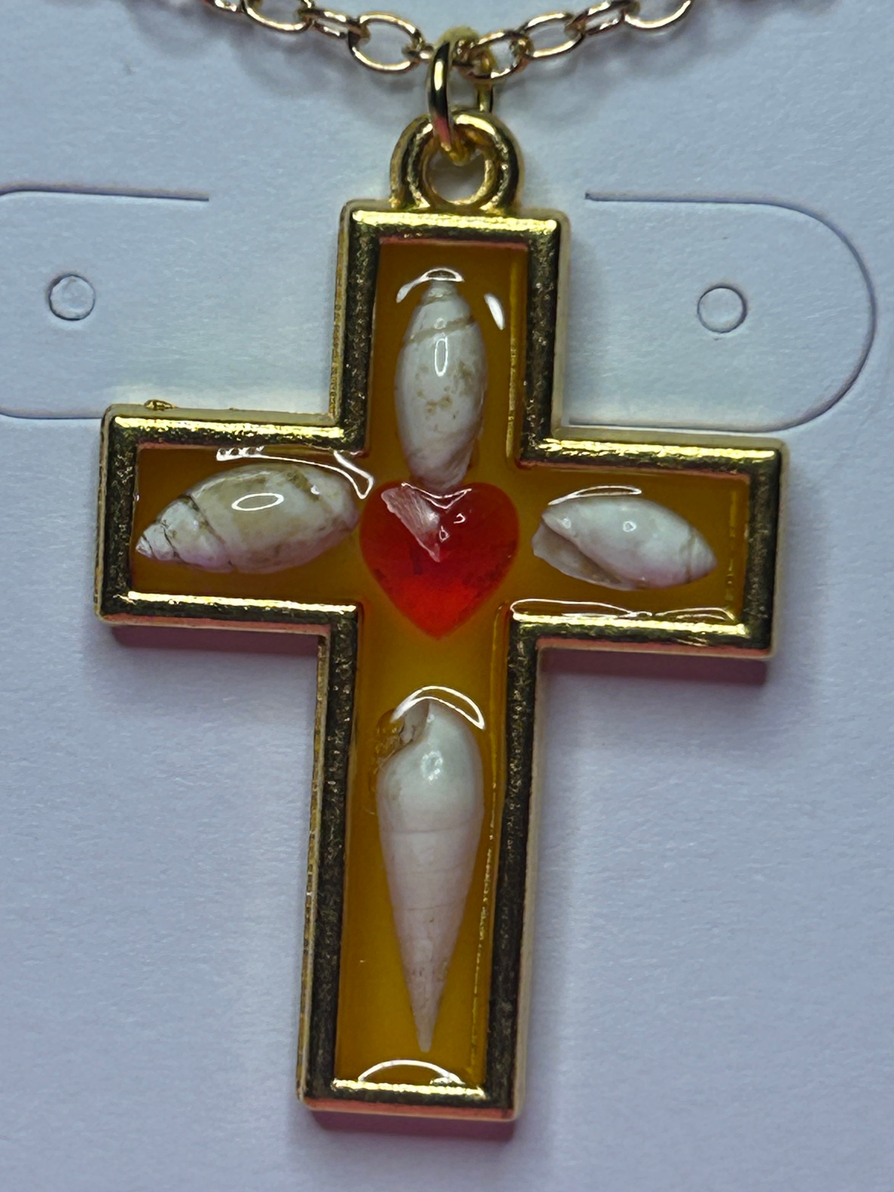 Gold cross with seashells and red heart